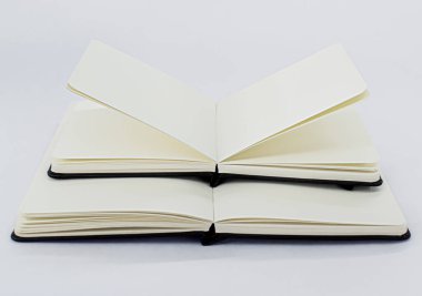 Siyah küçük bir not defteri aç ve boş bej sayfalı büyük bir defter aç. Beyaz arkaplan
