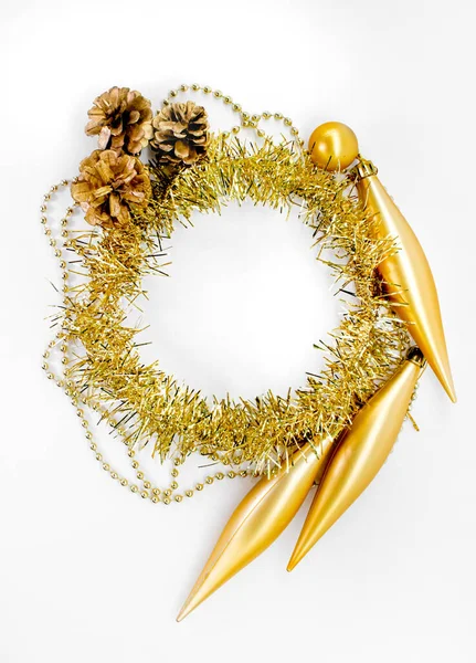 ティンセルのラウンドサークル クリスマスの長いおもちゃ 3つのバンプ ボールのチェーン ビーズ 白を背景に黄色と金色の新年の装飾 コンセプト — ストック写真