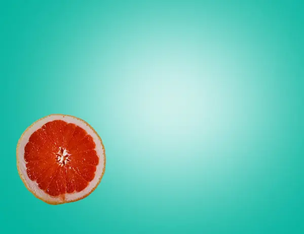 Wyciąć Jasnoczerwony Pomarańczowy Pół Grejpfruta Plasterek Kolorowe Jasnozielone Turkusowe Tło — Zdjęcie stockowe