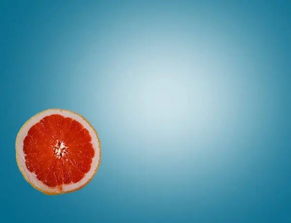Вырезать Ярко Красный Оранжевый Полугрейпфрутовый Ломтик Ярко Голубом Фоне — стоковое фото