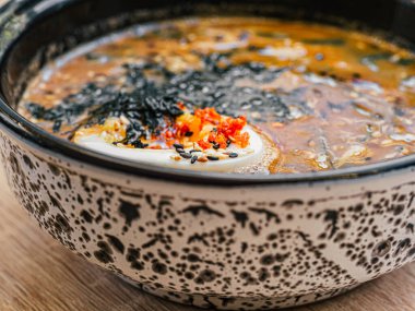 Kesilmiş yumurta, susam tohumları, siyah beyaz tabakta kırmızı miso çorbası içinde nori. Asya restoranında, kafede Japon mutfağı tabağı. Kapat.