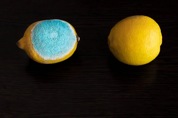 Zwei Ganze Gelbe Leuchtende Zitronen Auf Einem Dunklen Holztisch Eine Stockfoto