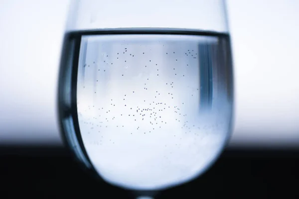 Genomskinligt Vinglas Med Vatten Mitten Små Bubblor Blå Svart Vit — Stockfoto