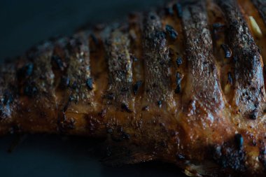 Çok iştah açıcı ve koyu bir tabakta pişmiş somon kuyruğu. Izgara tarifleri. Makro yemek fotoğrafı.