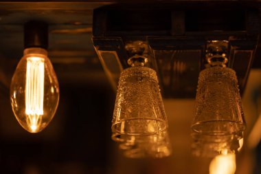 Alkollü içecekler, kokteyller, şarap, şampanya ve barın üstünde baş aşağı asılı martini için birkaç geometrik cam kadeh. Sıcak bir akşam.