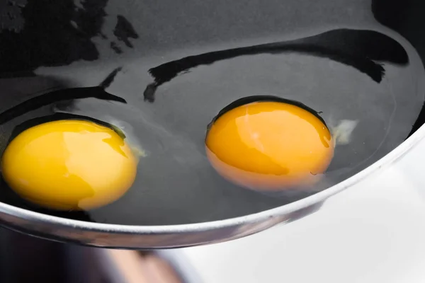 Два Сырых Ярких Круглых Желтка Прозрачном Белом Черной Серебряной Сковороде — стоковое фото