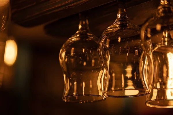 一些形状的玻璃杯 用于酒精饮料 鸡尾酒 红葡萄酒 葡萄酒 马提尼 倒挂在酒吧上方 温暖的夜光 — 图库照片