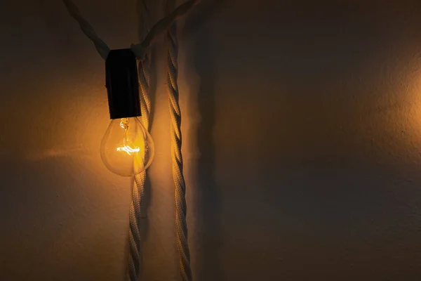 One Small Bulb Glowing Warm Orange Yellow Light Hang Wall — Stock Photo, Image