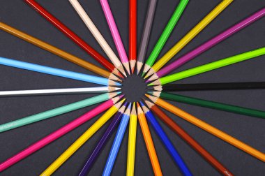 Siyah arkaplan üzerine dizilmiş renkli kalemler.