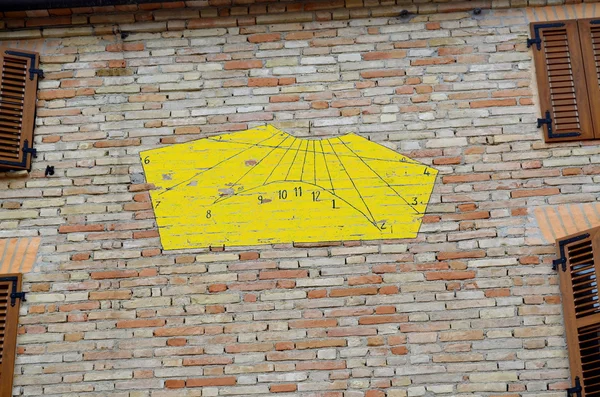 Yellow sundial on a house wall in Italy — Stock Photo, Image
