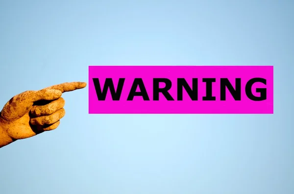 Human finger with rectangular purple label WARNING — Stock Photo, Image