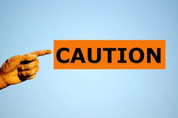 Finger with rectangular orange label CAUTION — Stock Photo, Image