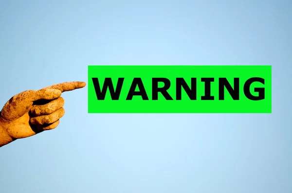 Human finger with rectangular green label WARNING — Stock Photo, Image