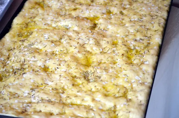 Frisch gebackenes Focaccia-Brot mit Rosmarinkraut überzogen — Stockfoto