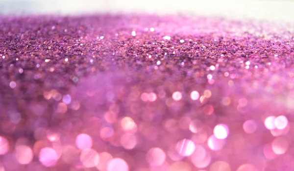 Fondo borroso de purpurina brilla sobre la superficie blanca — Foto de Stock