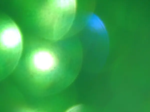 Intreepupil groene bokeh licht, achtergrond. — Stockfoto