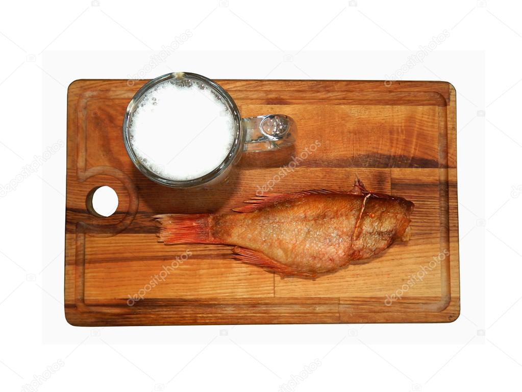 Mug of beer and smoked sea bass on a wooden board, isolated on white background, top view