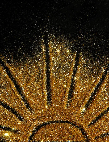 De zon van gouden glitter sparkle op zwarte achtergrond — Stockfoto