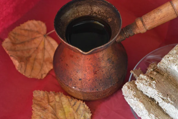 Old copper Turkish coffee pots, Middle Eastern sweets and yellow autumn leaf on burgundy surface, top view — Stock Photo, Image