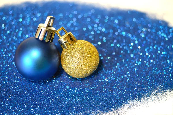 Blå och gyllene julgranskulor på blå glitter på vit bakgrund — Stockfoto
