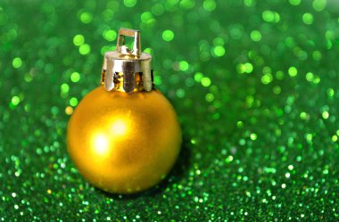 Altın Noel top yeşil glitter bulanık arka plan üzerinde