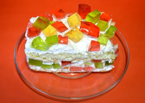 Apetyczny galaretka ciasto na przezroczyste naczynie na czerwonym tle — Zdjęcie stockowe