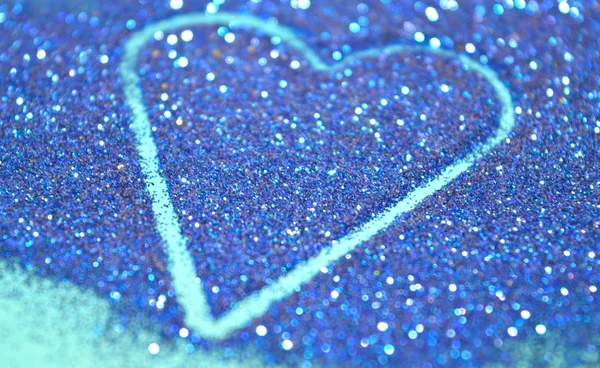 Sfondo astratto sfocato con cuore di brillantini blu scintilla sulla superficie blu — Foto Stock