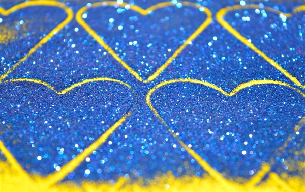 Wazig abstracte achtergrond met harten van blue glitter sparkle op gele oppervlak — Stockfoto