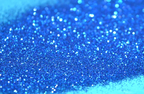 Onscherpe achtergrond van blauwe glitter schittert op blauwe oppervlak — Stockfoto