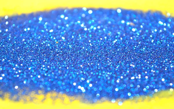 Fond trouble de paillettes bleues scintille sur la surface jaune — Photo