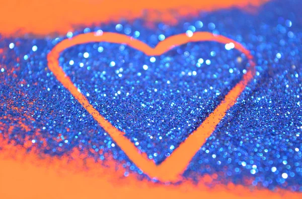 Suddiga abstrakt bakgrund med hjärta av blå glitter glitter på röd yta — Stockfoto