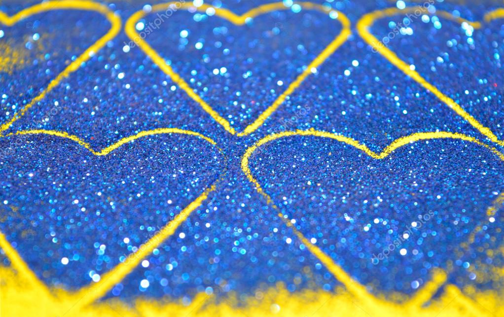 Blurry abstract background with hearts of blue glitter sparkle on