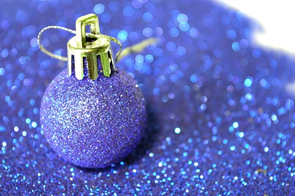 Blauwe bal met het Kerstmis op onscherpe achtergrond van blauw glitter — Stockfoto