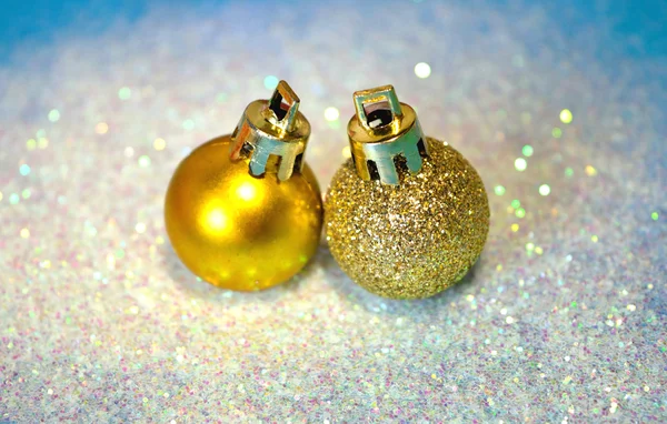 Δύο χρυσές μπάλες Χριστούγεννα στο λευκό ακτινοβολεί σε μπλε φόντο — Φωτογραφία Αρχείου