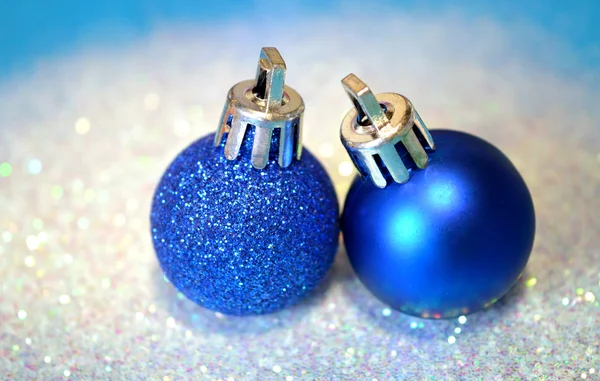 Twee blauwe kerstballen op witte glitter op blauwe achtergrond — Stockfoto