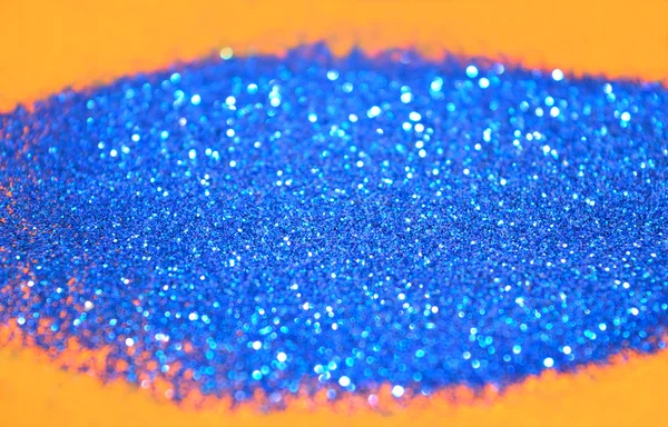 Onscherpe achtergrond van blauwe glitter schittert op oranje oppervlak — Stockfoto