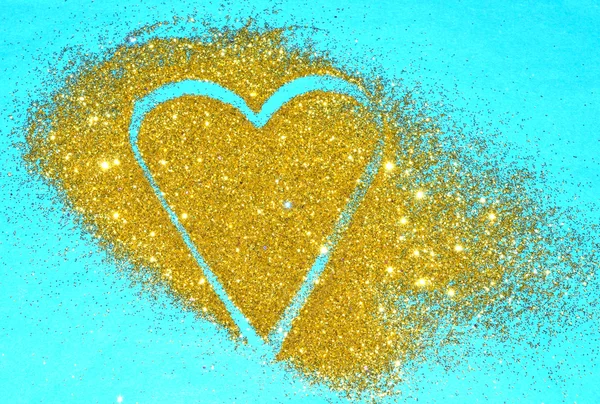 Abstrakt hjärtat av guld glitter glitter på blå bakgrund — Stockfoto