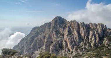 Büyük bir dağın etrafında hareket eden bulutların zaman akışı