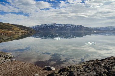 Çok sakin bir deniz ve yüzen küçük buz parçalarıyla bir fiord 'un deniz manzarası