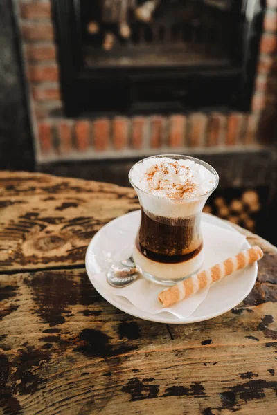 a cup of coffee in a bar, on a vintage rustic wooden table. it is a coffee with chocolate, very sweet.