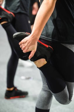 Sporcu koşudan sonra kaslarını esnetiyor. İki kadın antrenman gününden önce bacaklarını esnetiyor, tarafsız bir tonla..