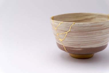 Kintsugi Japon bej çay fincanı, altın çatlaklar, antik Japon restorasyon tekniği. Japon çay fincanı altınla yenilendi.