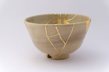 Kintsugi Japanese beige tea cup , gold cracks, antique Japanese restoration technique. Japanese tea ceremony cup restored with gold. clipart