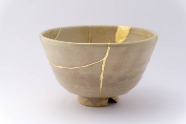 Kintsugi Japon bej çay fincanı, altın çatlaklar, antik Japon restorasyon tekniği. Japon çay fincanı altınla yenilendi.