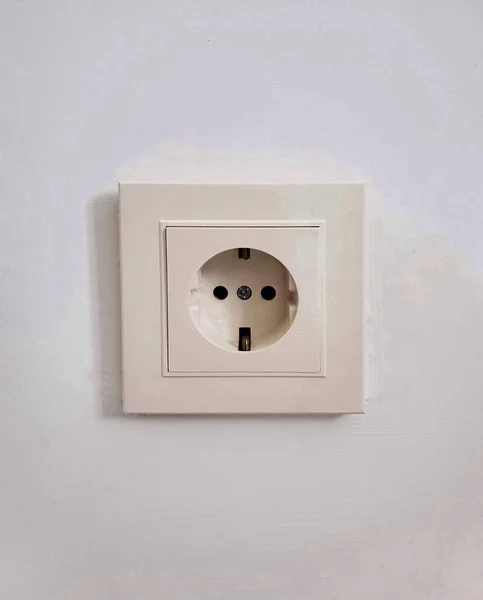 Gray wall with european electric outlet socket.