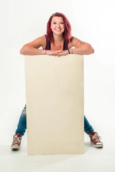 Joven mujer sonriente sosteniendo una pancarta blanca en blanco — Foto de Stock