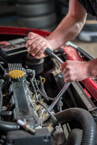 Mecánico de coche en servicio de reparación de automóviles, arranque del enchufe de encendido —  Fotos de Stock