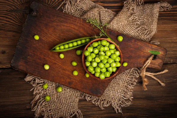 Ervilhas verdes orgânicas frescas em um fundo de madeira.Estilo rústico . — Fotografia de Stock