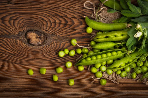 Frische grüne Bio-Erbsen auf einem hölzernen Hintergrund. Rustikaler Stil. — Stockfoto