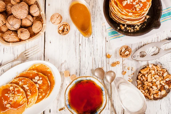 Crêpes au caramel et noix sur un vieux fond en bois . — Photo